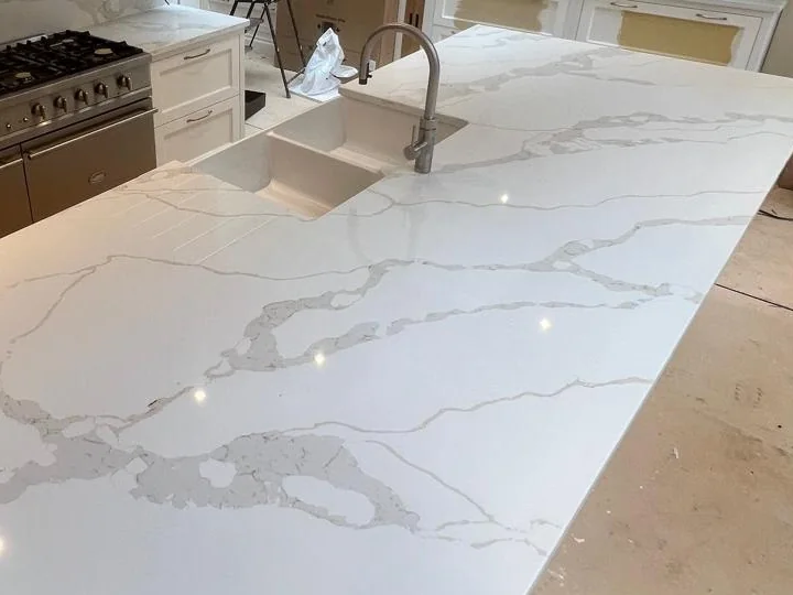 Undermounted sink bowls and polished edges in a veined quartz island