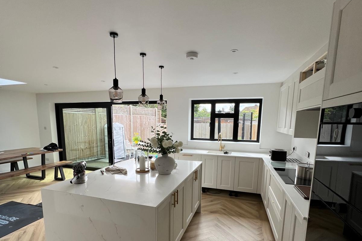 White quartz kitchen with an island and dining area